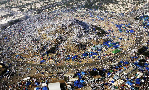 Pilgrims standing on the small hill of Arafat in Mecca