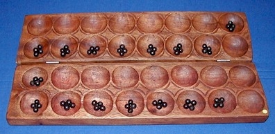 Omweso is a Mancala type game from Uganda, with 4 rows. Note that the seeds are small, and the holes are large, in order to accommodate a large number of seeds, which could accumulate to more than twenty in a spot. The picture of Omweso on the right was been taken from The Online Guide to Traditional Games. Used with permission. 	