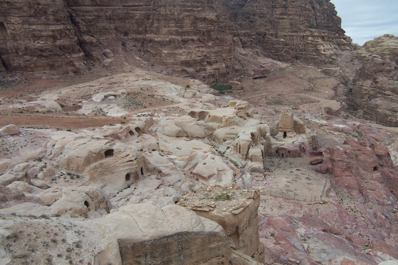 Looking at the caves from above with a large block in the background marking the border of the sacred area.